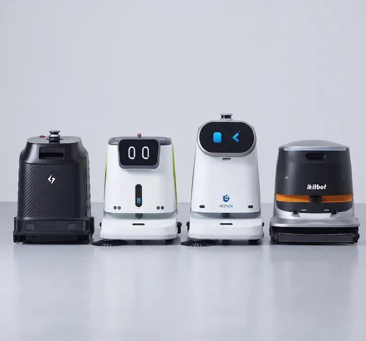 Cuatro robots de limpieza profesionales de distintas marcas, uno al lado del otro