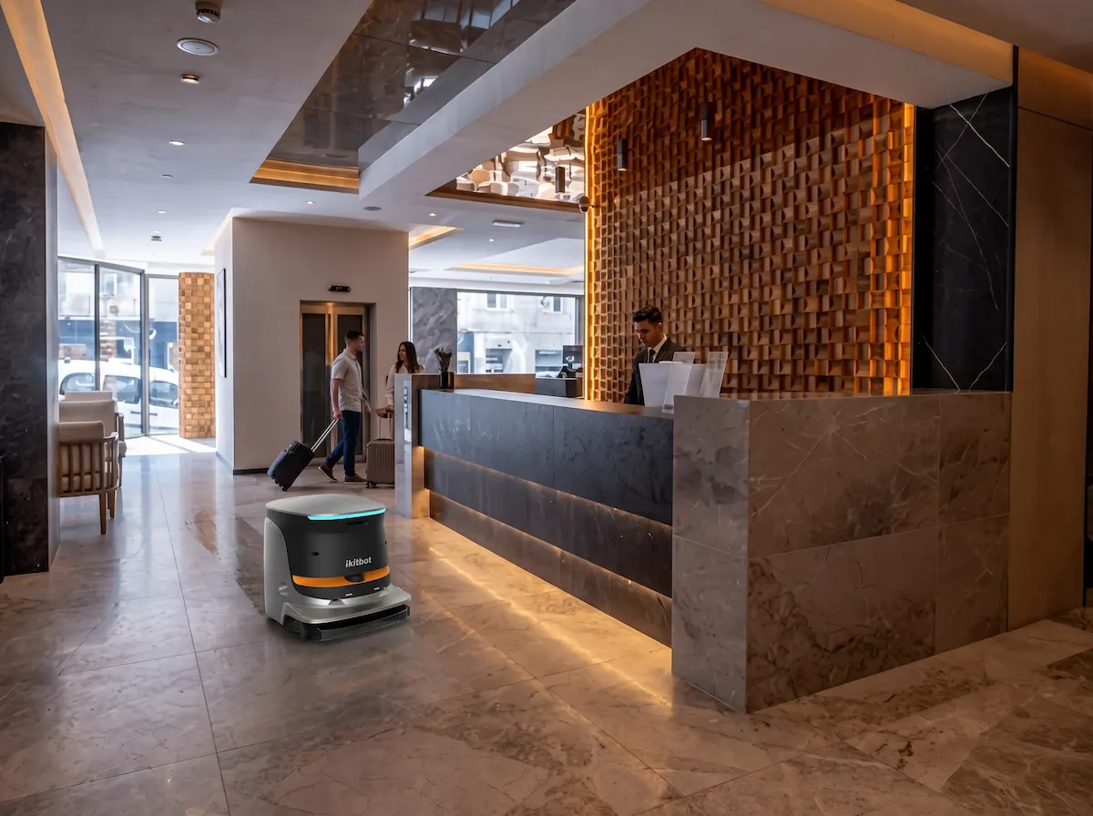 Robot de limpieza Amerevo ONE limpiando el vestíbulo junto a la recepción de un hotel