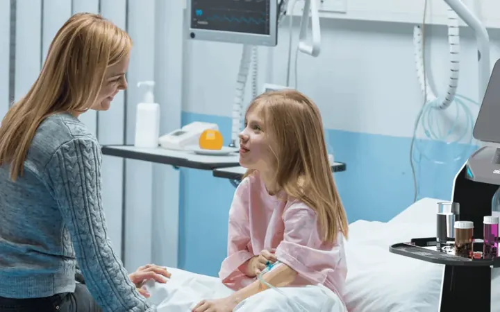 Paciente y acompañante en una habitación de hospital con un robot de servicio al fondo